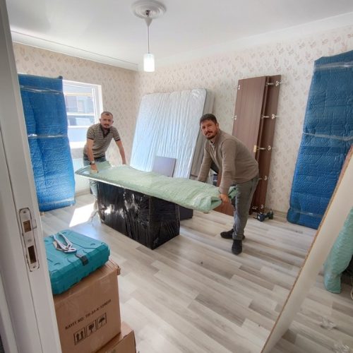 İki kişilik ekibin paketlenmiş mobilyayı taşıması